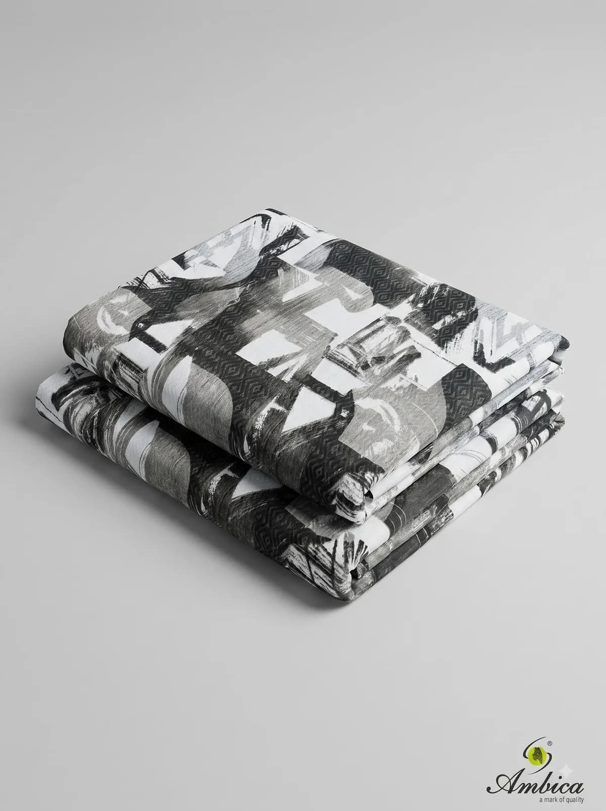 Folded black and white abstract brushstroke print fabrics on a grey background