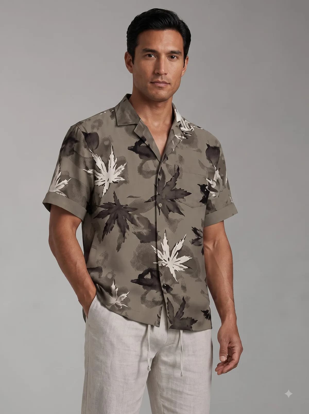 Model in a taupe camp collar shirt with a watercolour maple leaf print