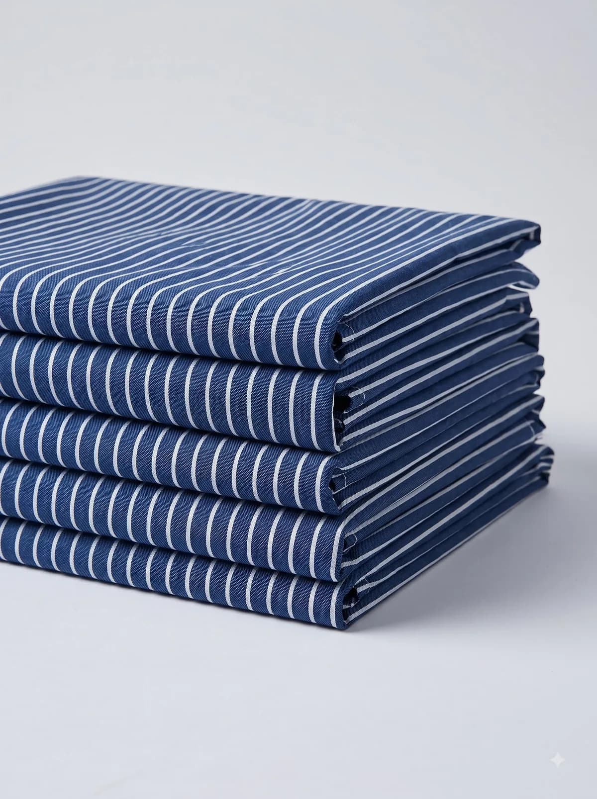 Stack of folded navy and white pinstripe fabrics